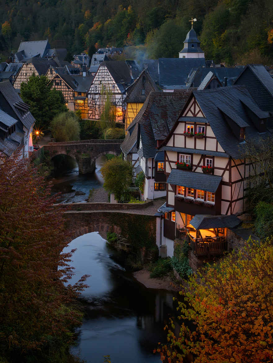 Romantisches deutsches Flussdorf mit historischen Fachwerkhäusern im Abendlicht